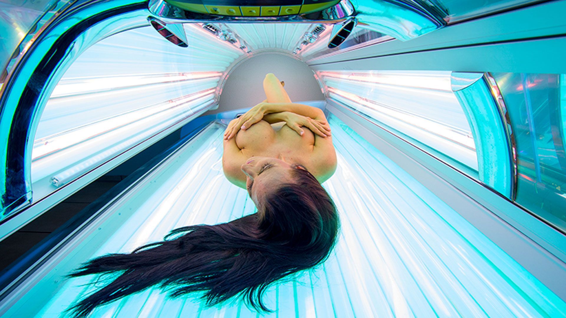 Eine Frau liegt in einem Solarium