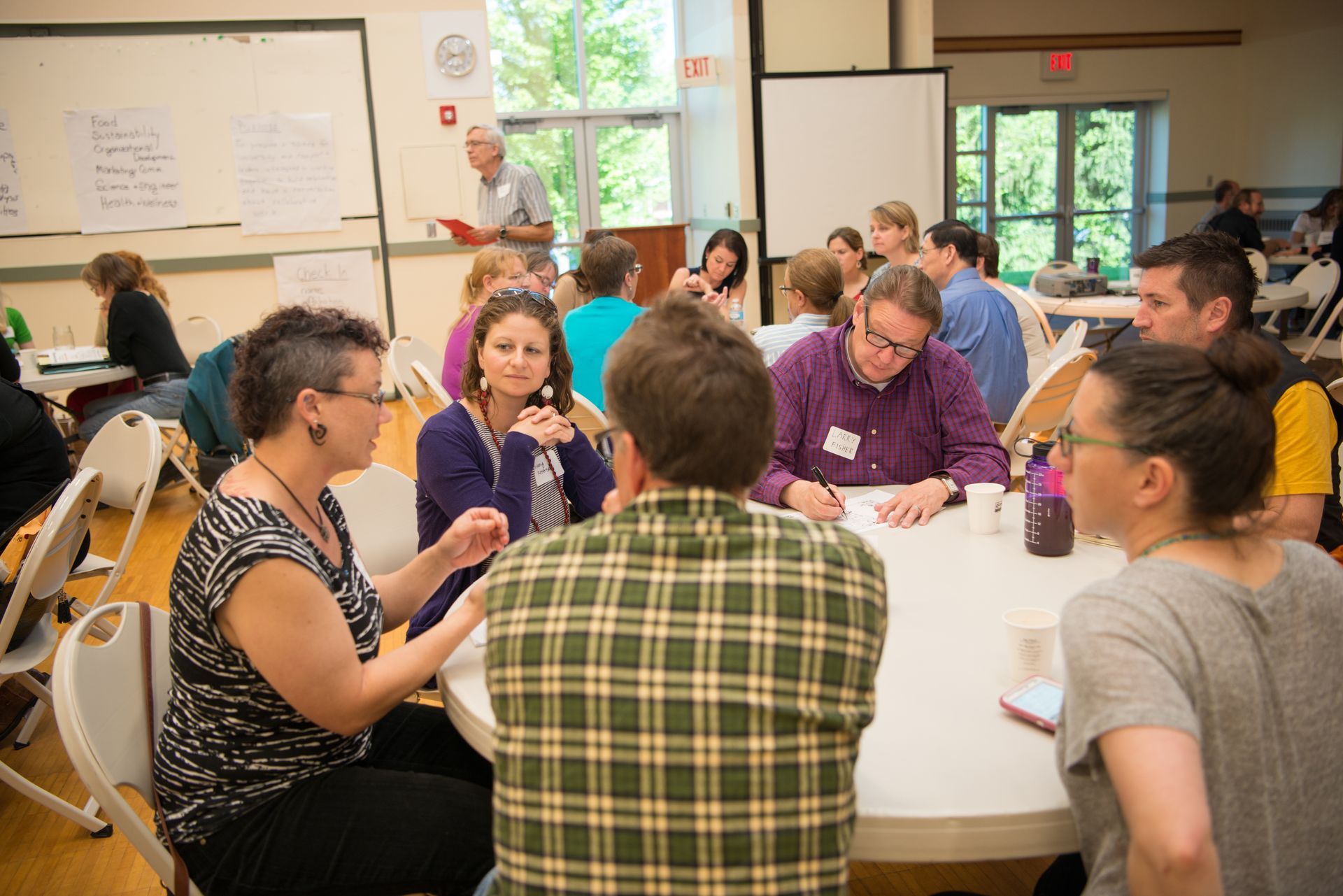 A group of people are sitting around a table in a room.