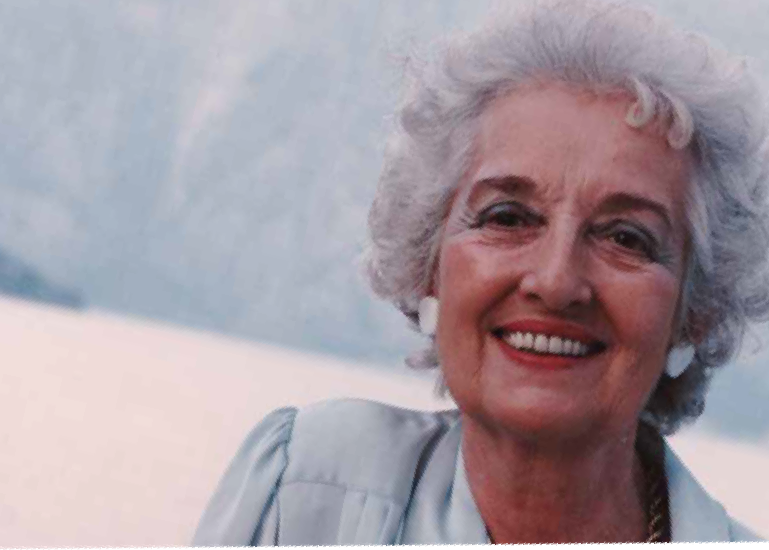 An elderly woman with gray hair is smiling for the camera.