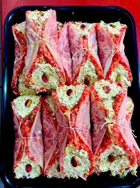 Vassoio di piadine rosse e verdi tagliate a fette e disposte in file con stuzzicadenti.