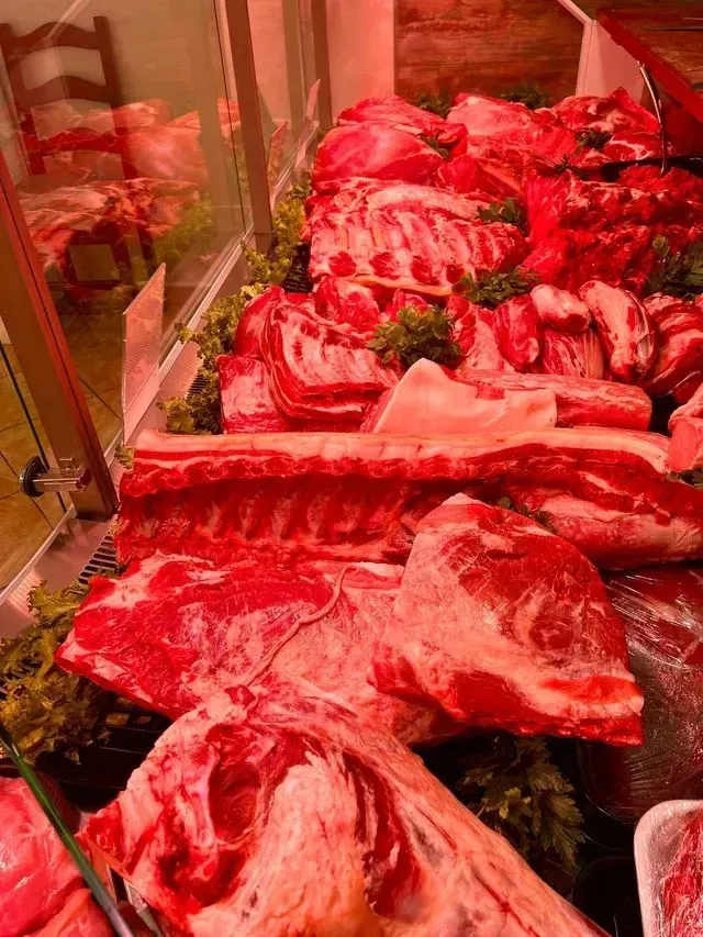 Vetrina espositiva di tagli di carne rossa cruda con marezzatura e costole in una macelleria