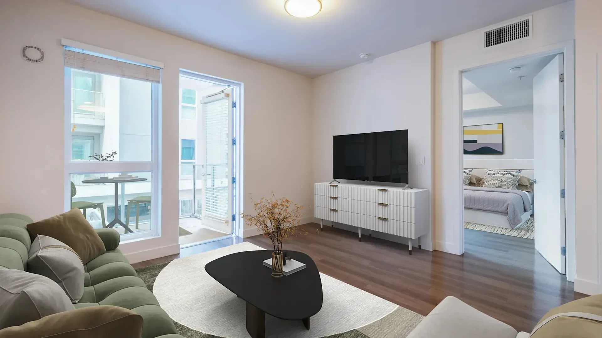 Living room with sofa, coffee table, TV, and balcony view.