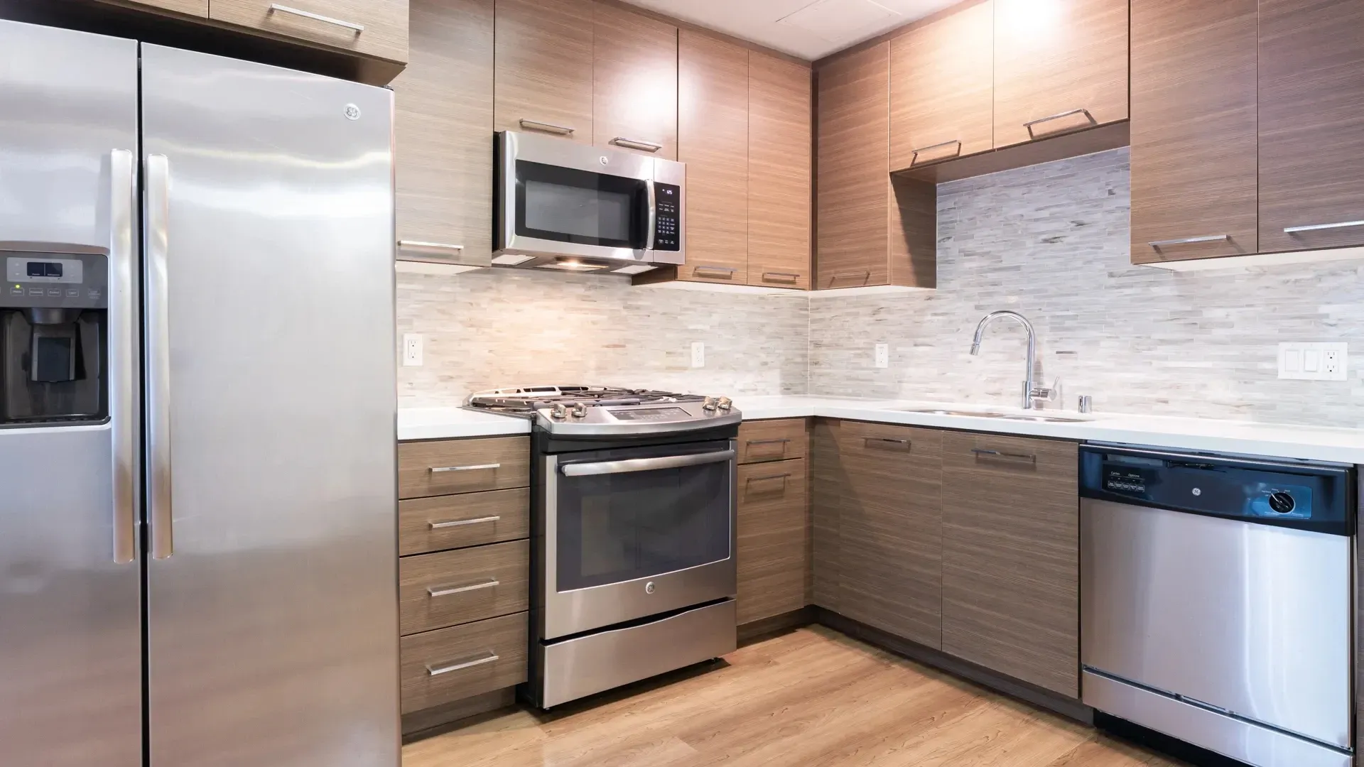 Modern kitchen with stainless steel appliances and wood cabinets.