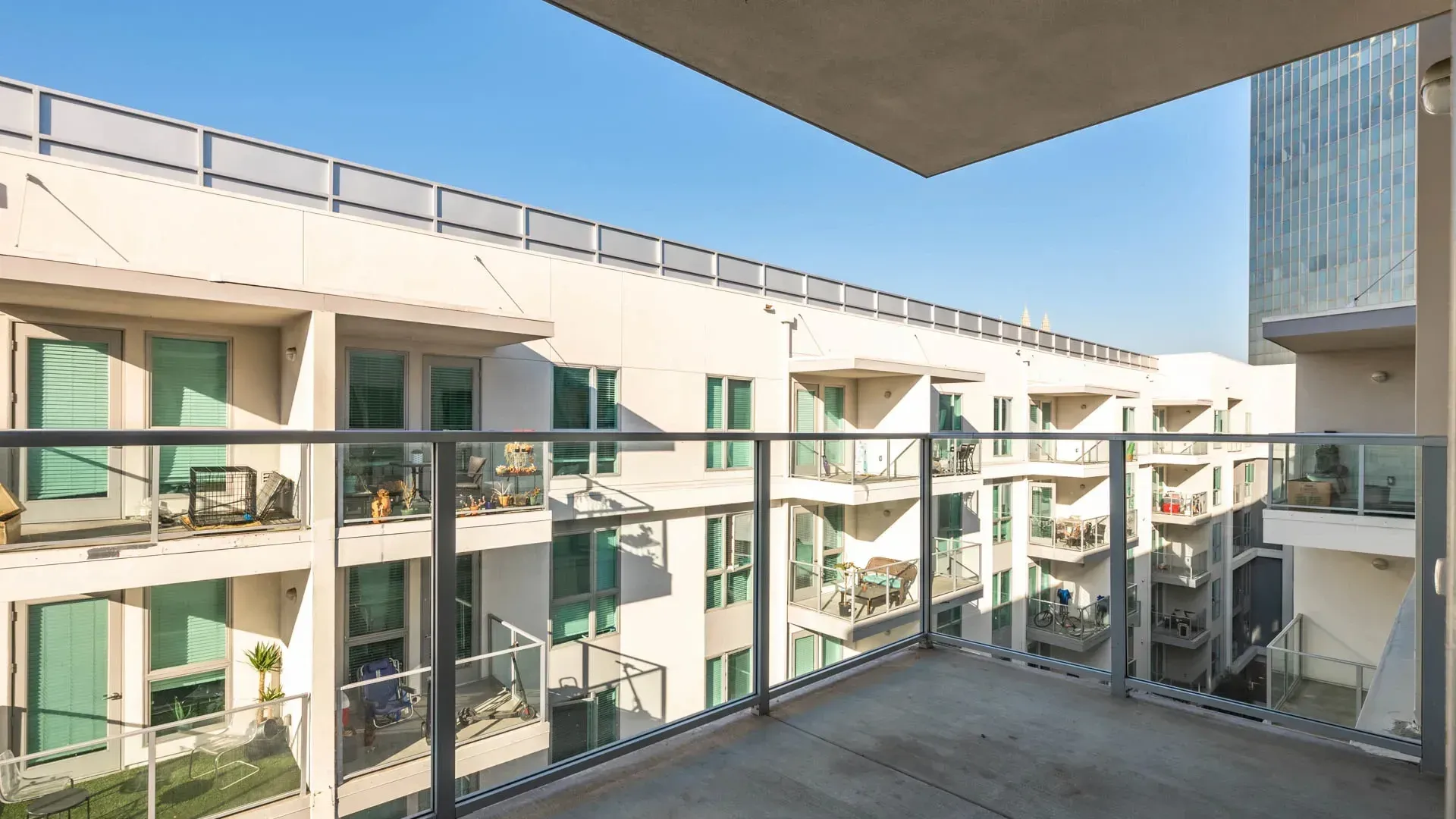 View of balconies and exterior of apartment buildings on a sunny day.