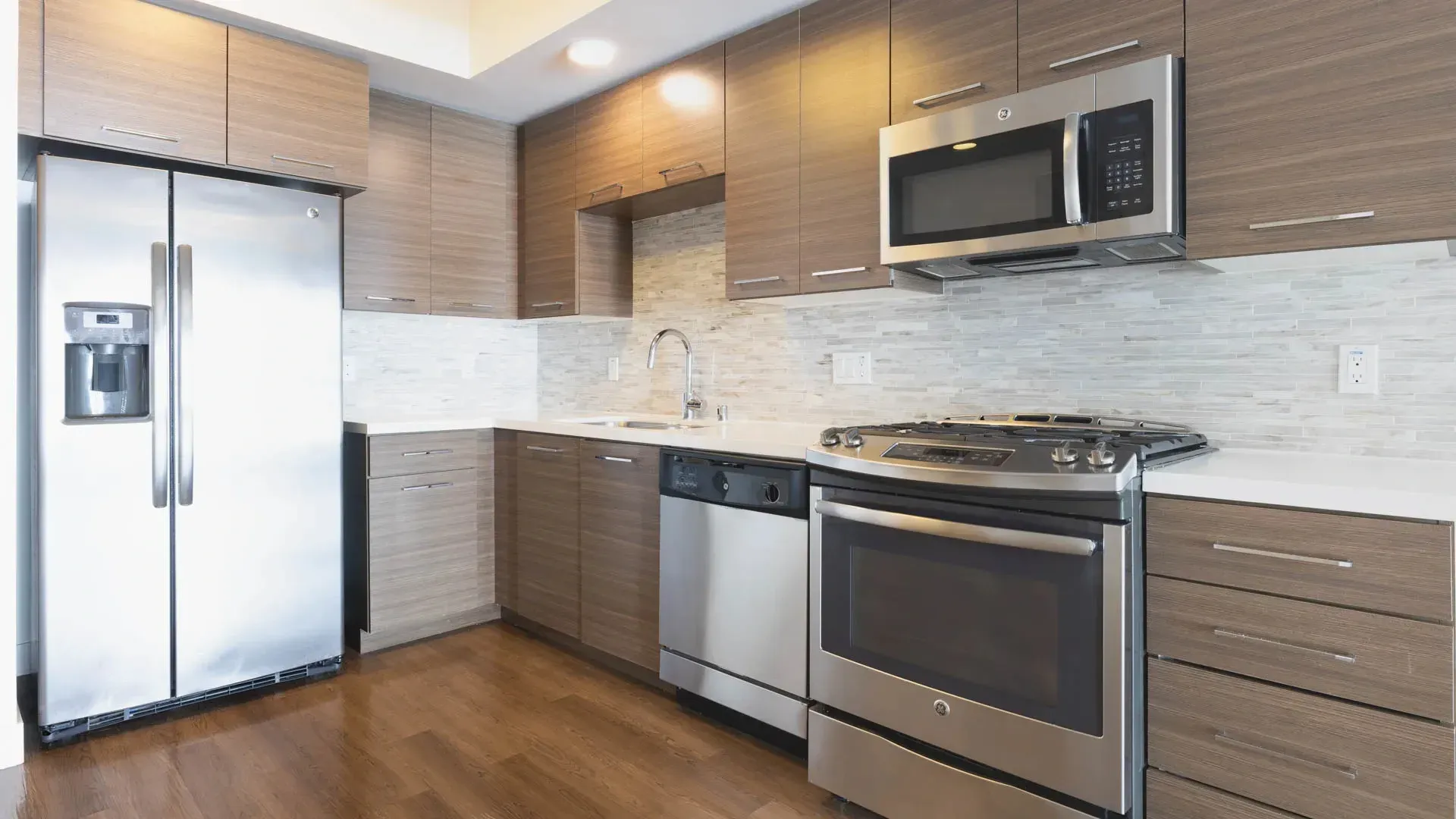 Modern kitchen with stainless steel appliances and wood cabinetry.