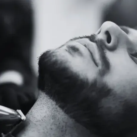 Man's face tilted back, being trimmed with a trimmer at a barber shop, close-up,  at The Fade Brothers - Indianapolis, IN