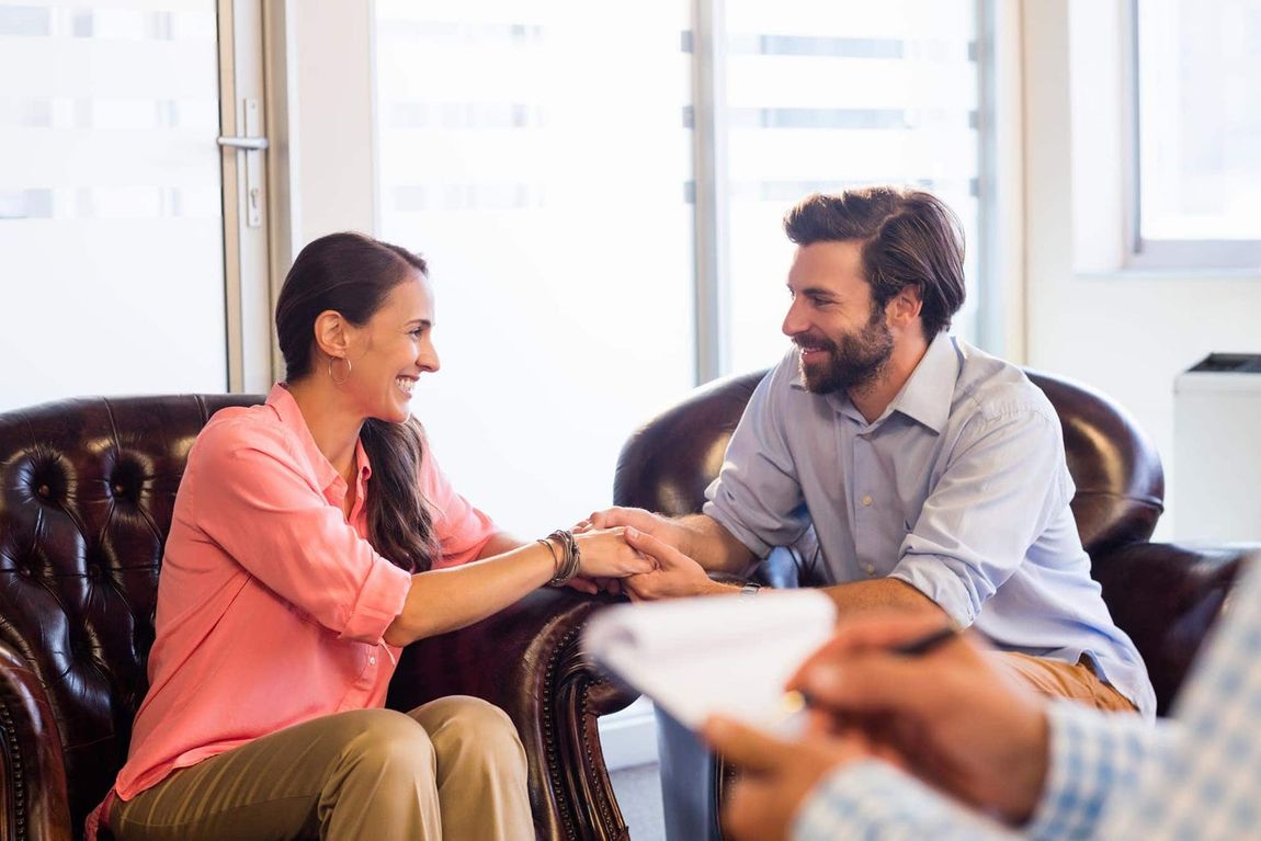 happy couple in front of counselor