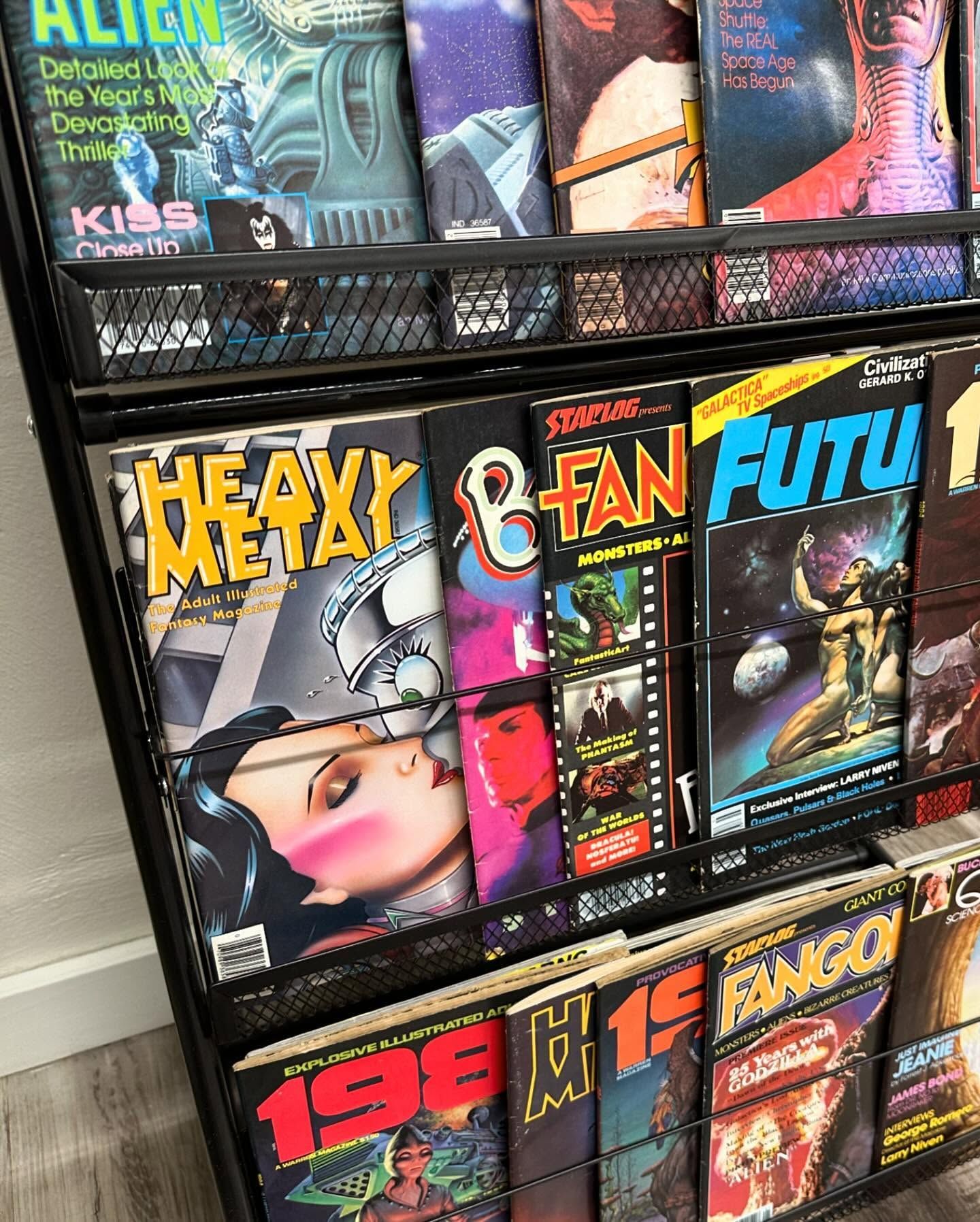 Comic-book store shelf with colorful issue covers, including Heavy Metal, Fan, Futic, and 1980 titles.