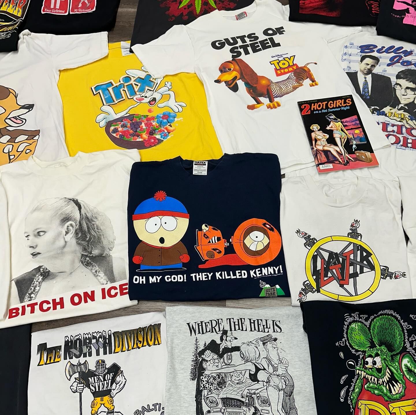 Assorted band graphic T-shirts laid out on a white surface.
