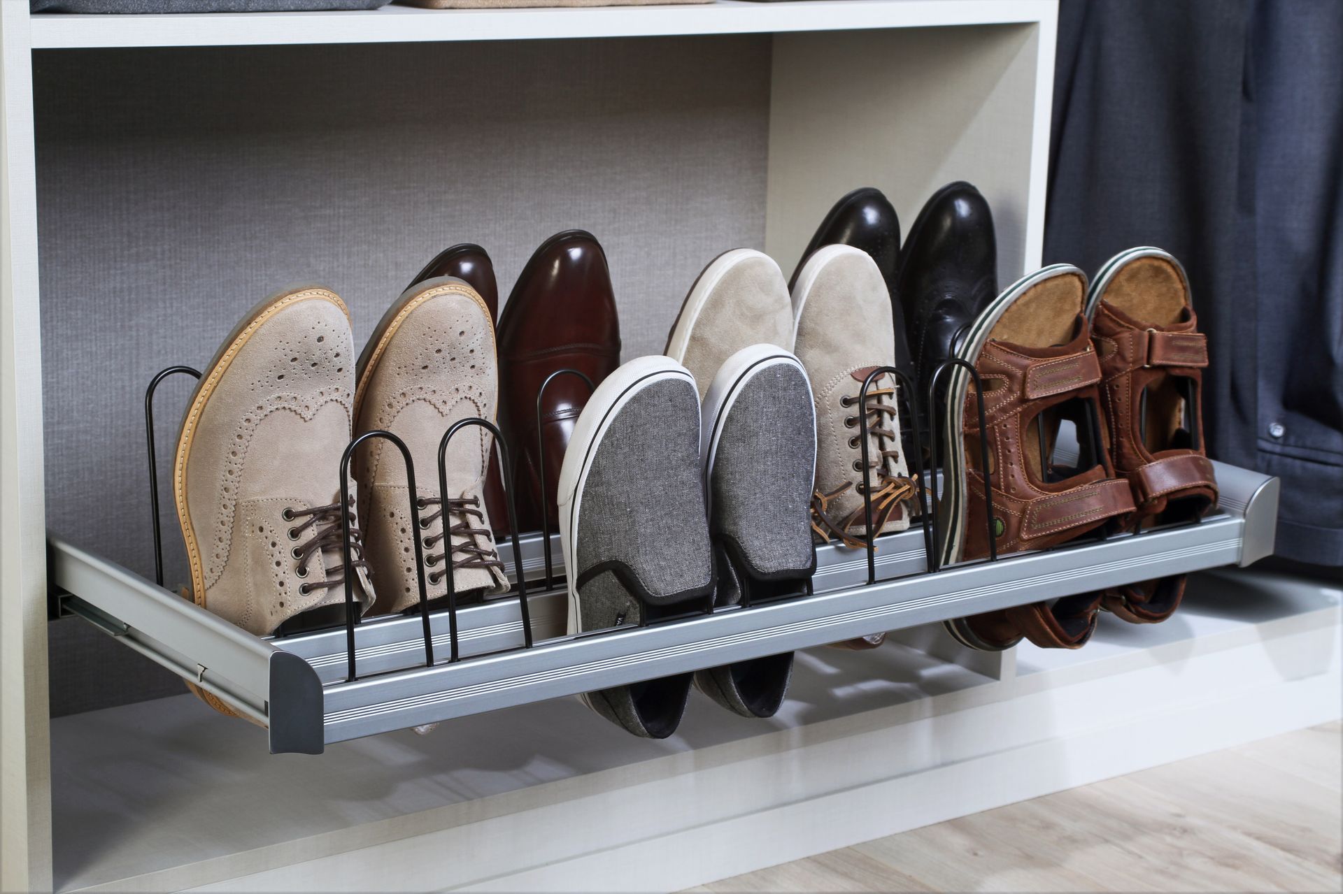 Shoes neatly arranged on a pull-out rack inside a white closet