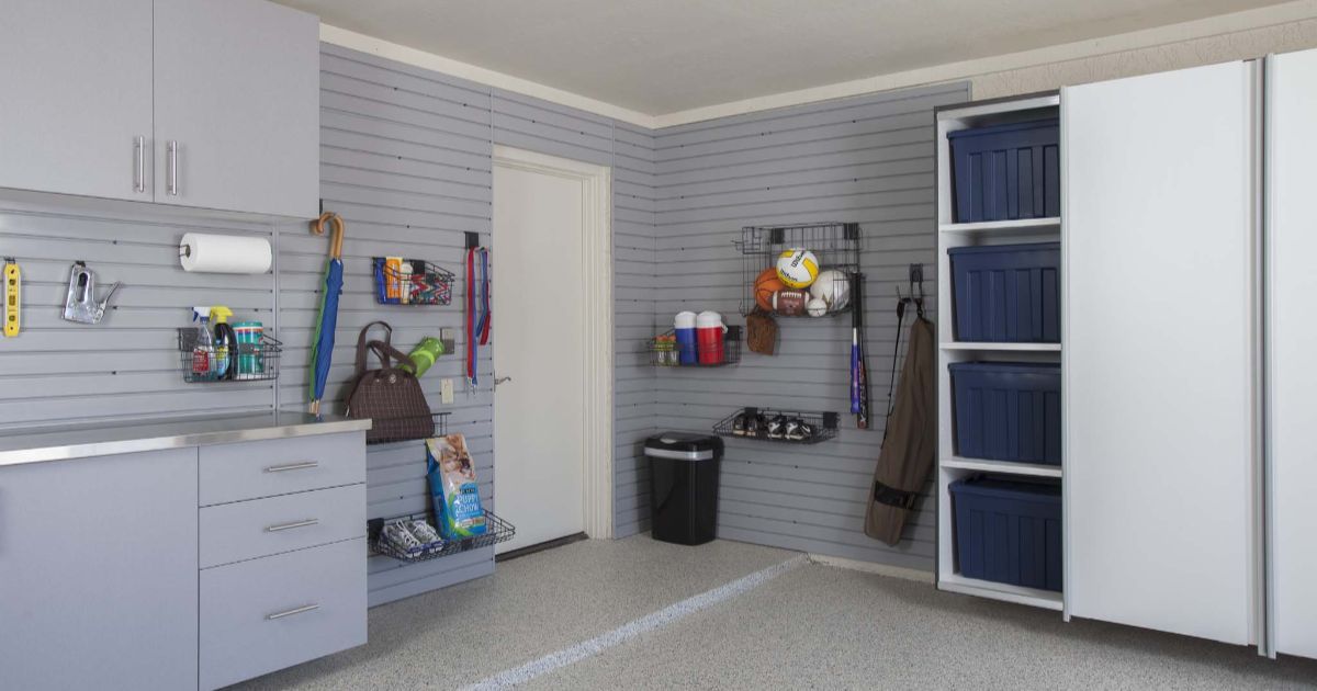 Garage interior with gray and white storage cabinets, wall organizers, and a door.