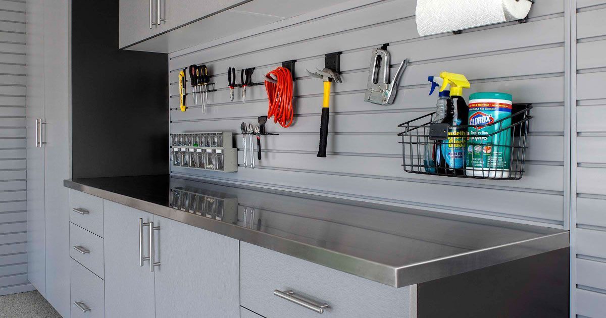 A well-organized walk-in closet with teal cabinetry and white shelving. Clothes hang, and decorative items are on display.