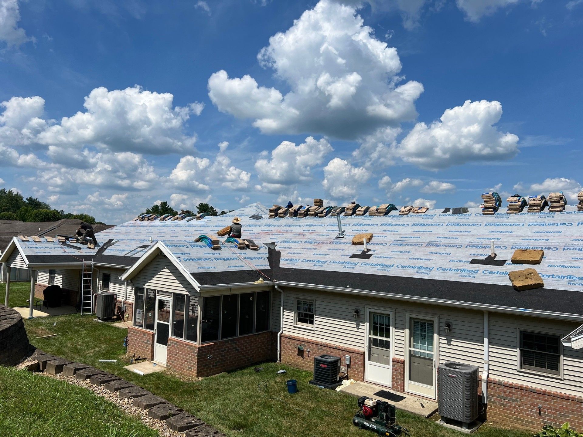 Roof with underlayment installed and shingle bundles staged during re-roofing.