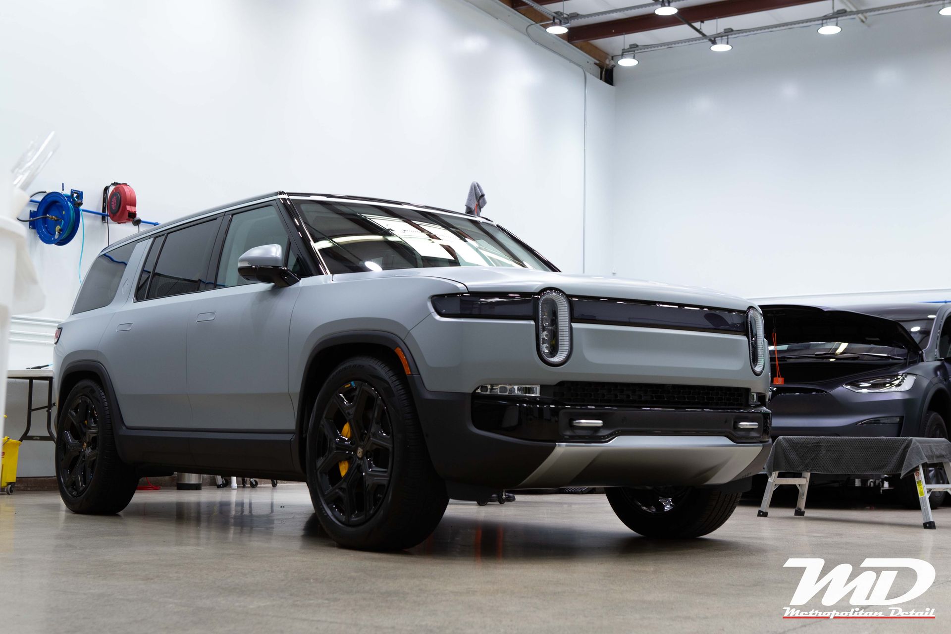 A gray suv is parked in a garage.