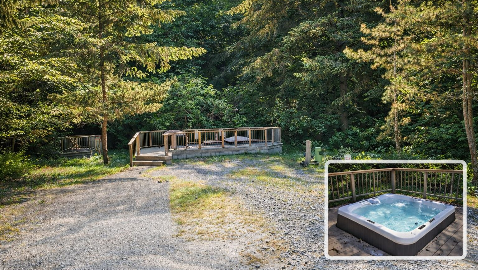 Gravel path leading to a wooded campsite with cabins and a hot tub inset in the corner.