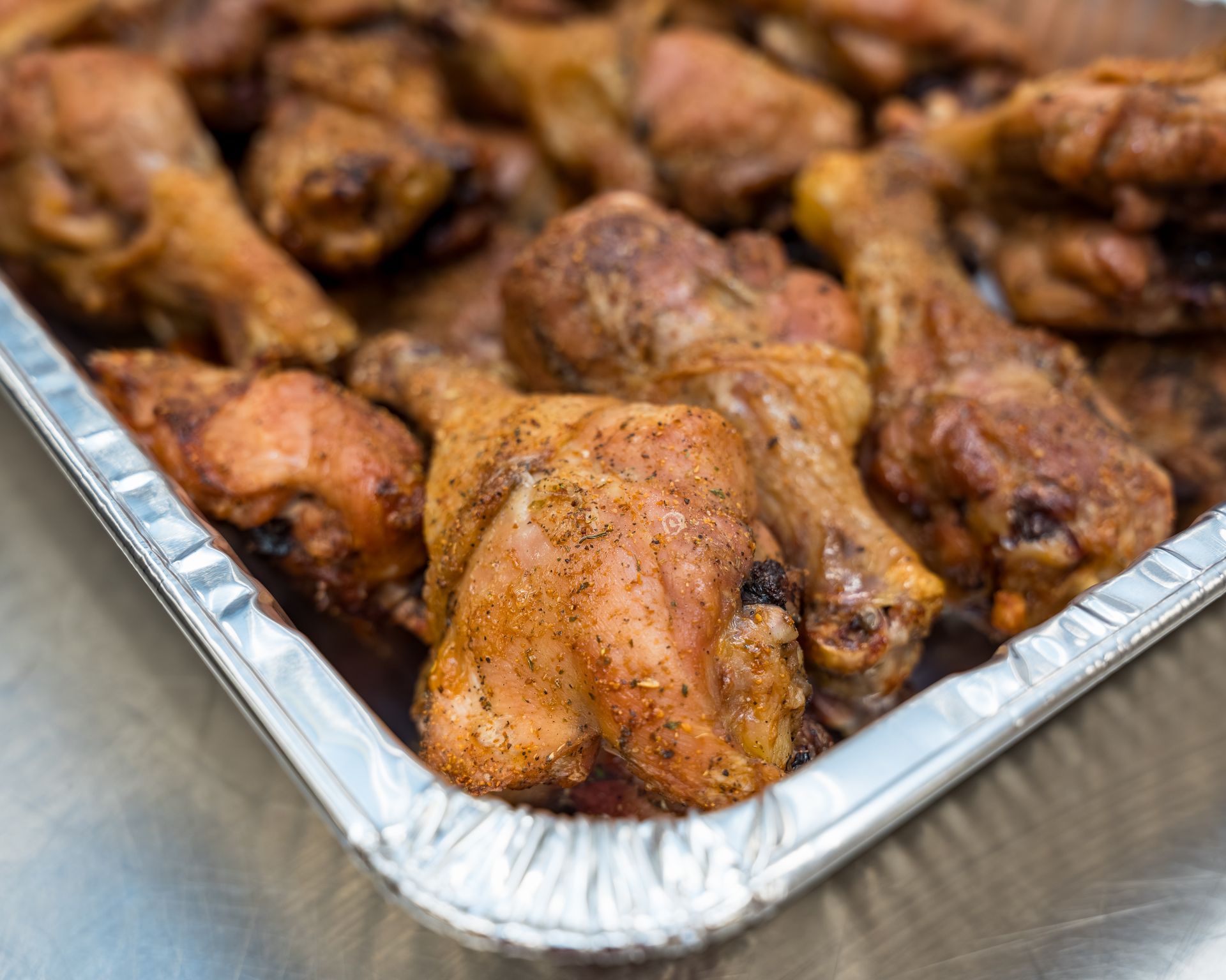 Tray of baked chicken wings in aluminum pan