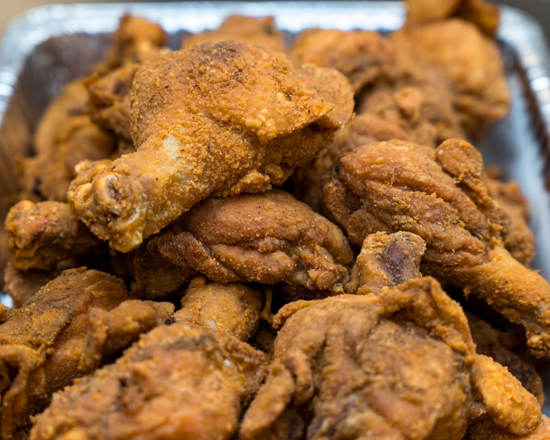 Tray of crispy fried chicken pieces piled together