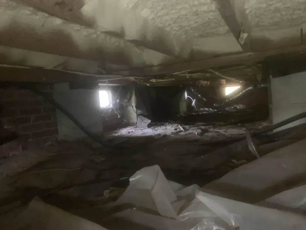 Collapsed ceiling in a dim interior, with rubble and debris scattered across the floor.