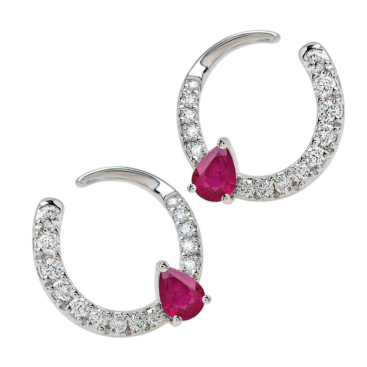 Un paio di orecchini a cerchio in argento con pietre scintillanti e gemme rosa a goccia.