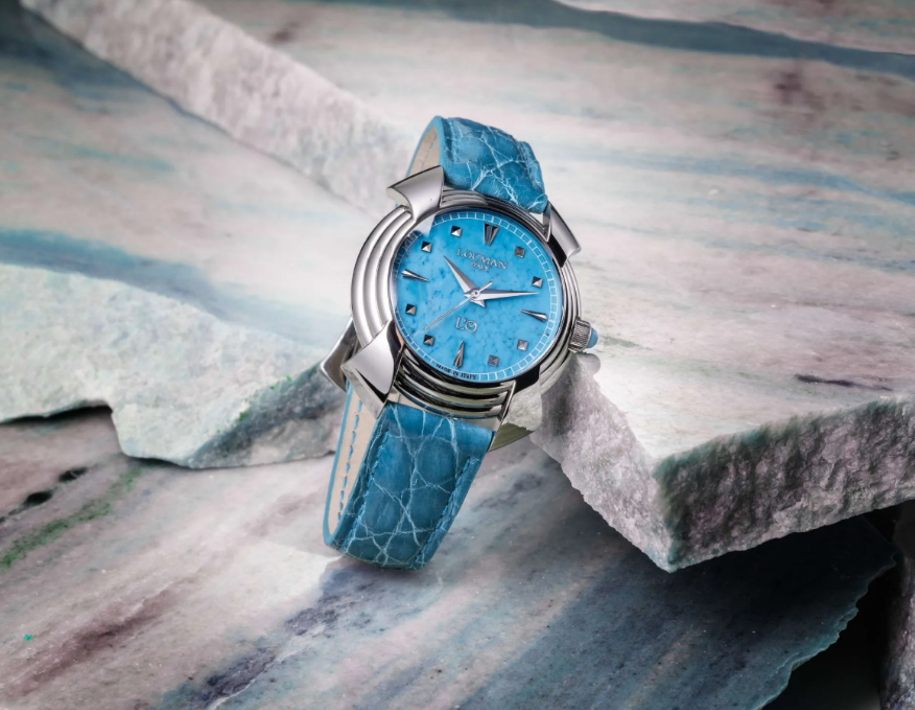 Orologio da polso blu con cinturino abbinato su superficie in pietra texturizzata.