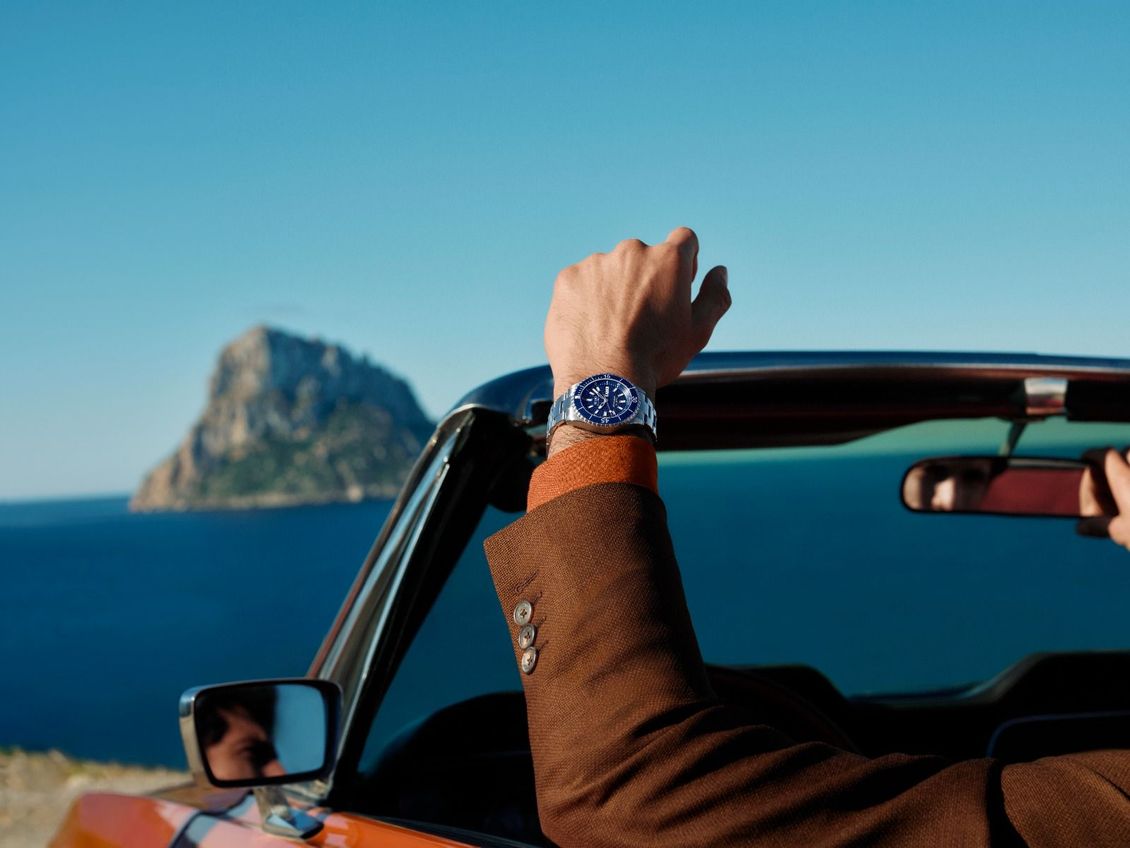 Orologio cronografo Blue Mido con cinturino blu navy su sfondo in tessuto blu testurizzato.