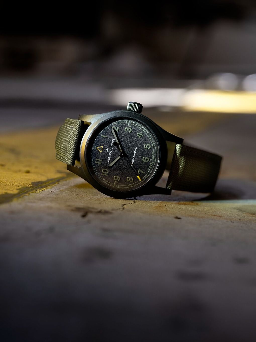 Primo piano di un orologio da polso al polso di una persona, su sfondo blu.