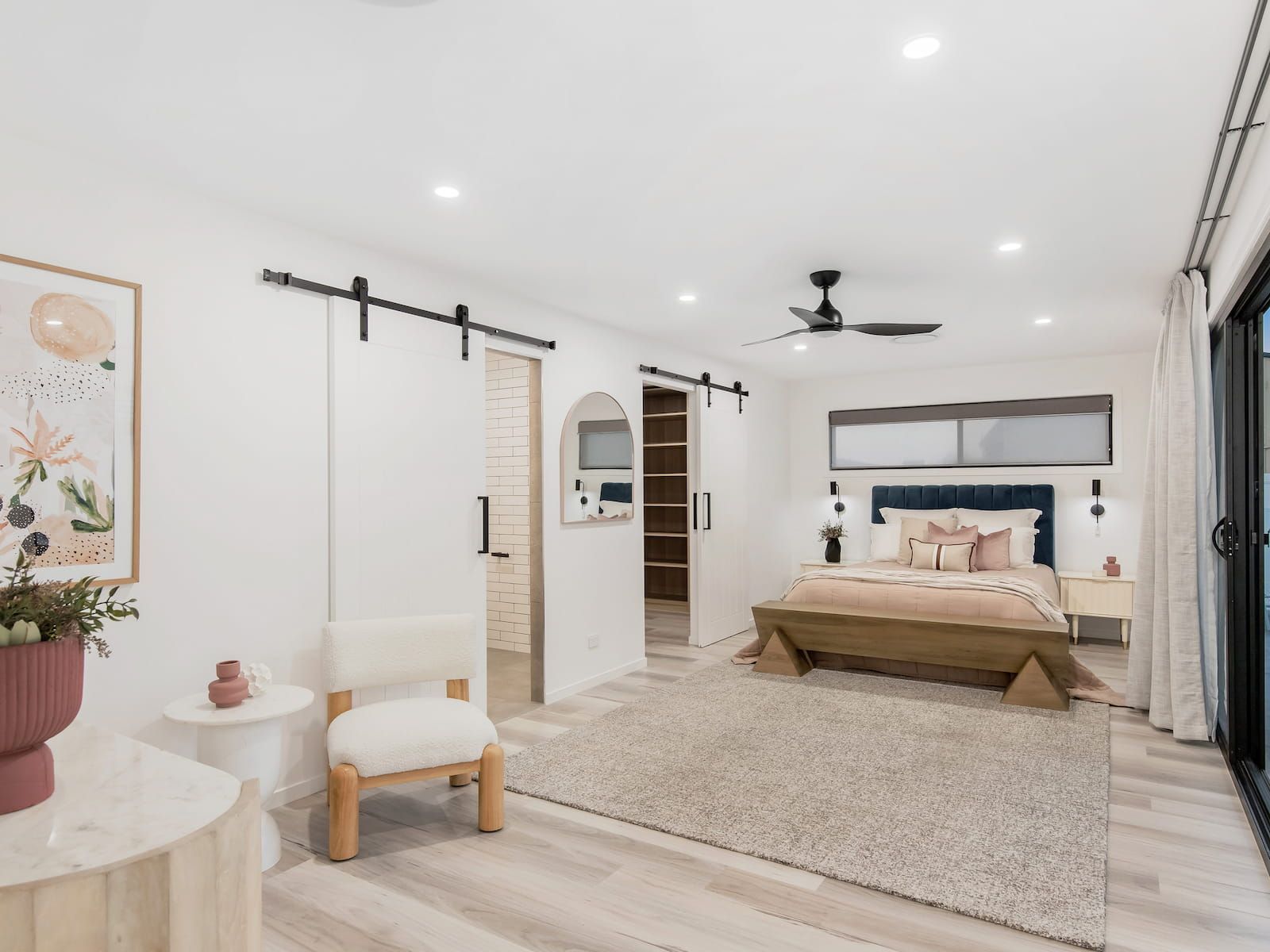 Bedroom with white walls, sliding barn doors, a bed, and a rug.