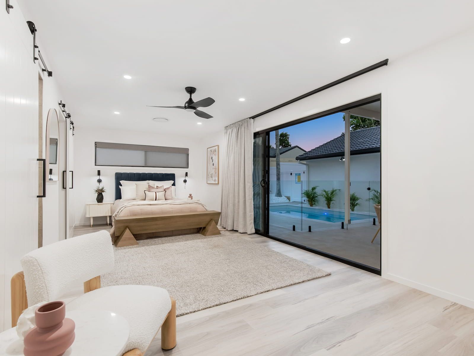 A kitchen with white cabinets , a sink and a refrigerator.