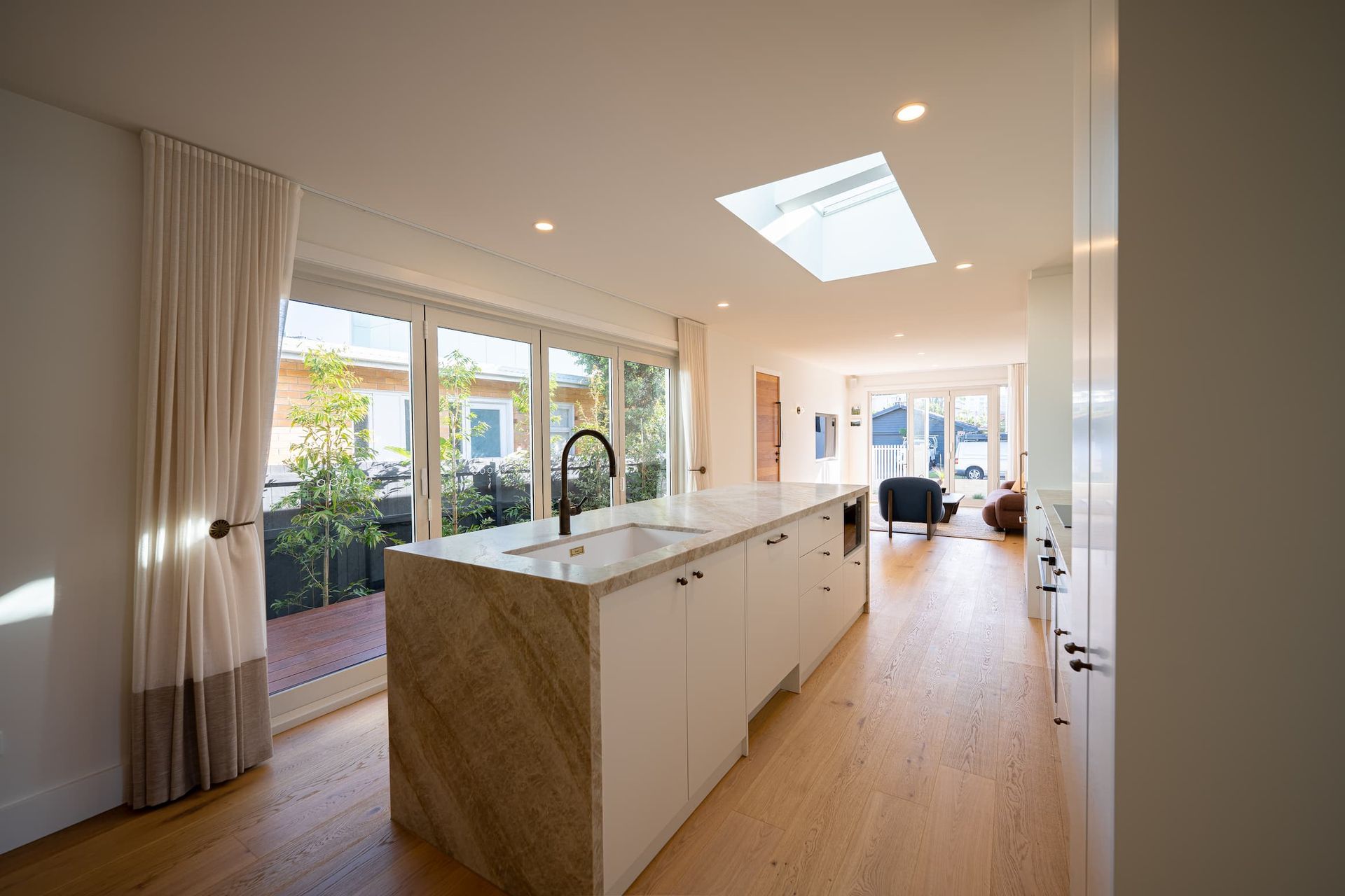 A kitchen with white cabinets , a sink and a refrigerator.