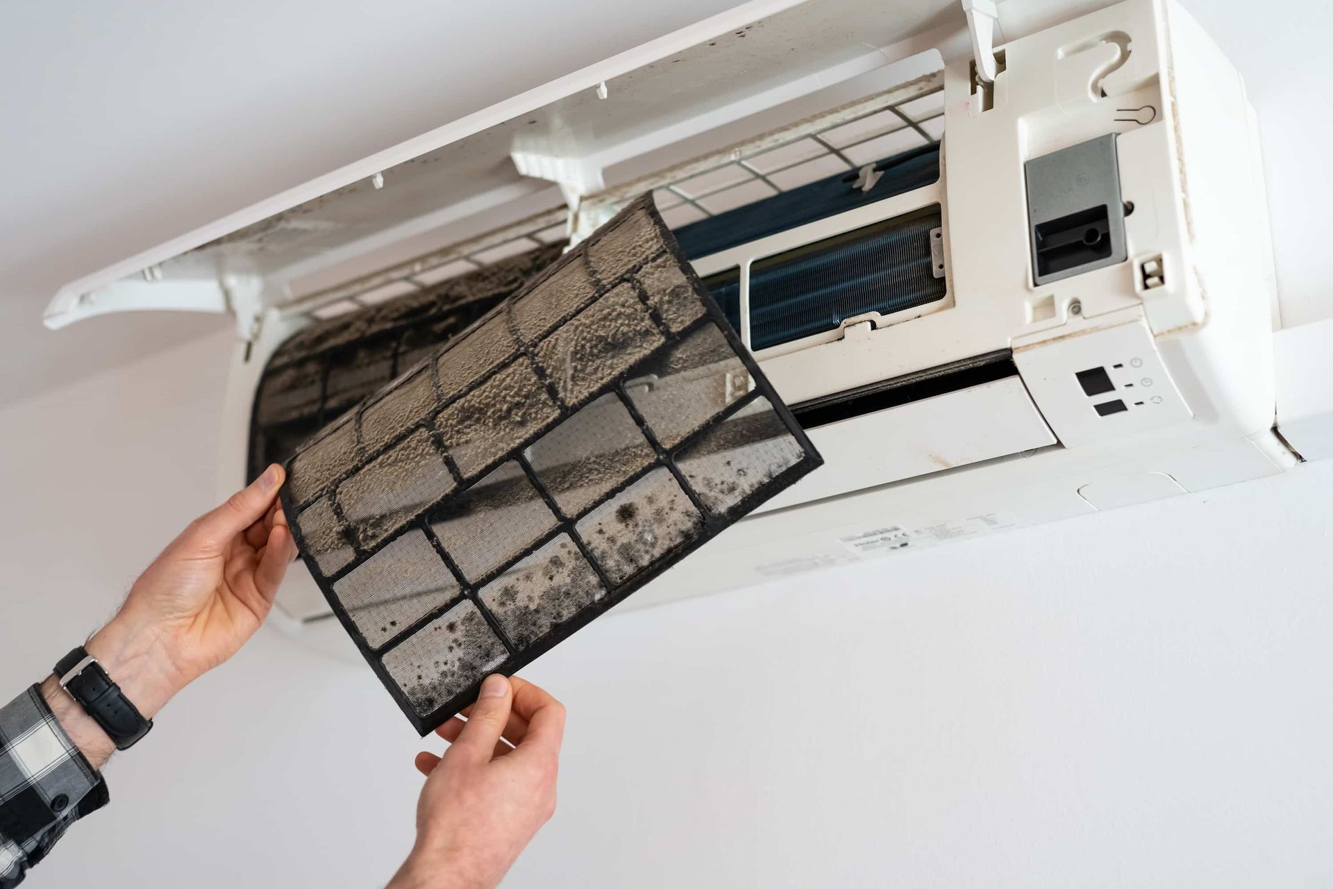 Person Removing Dirty Air Conditioner Filter - Electrician Gold Coast