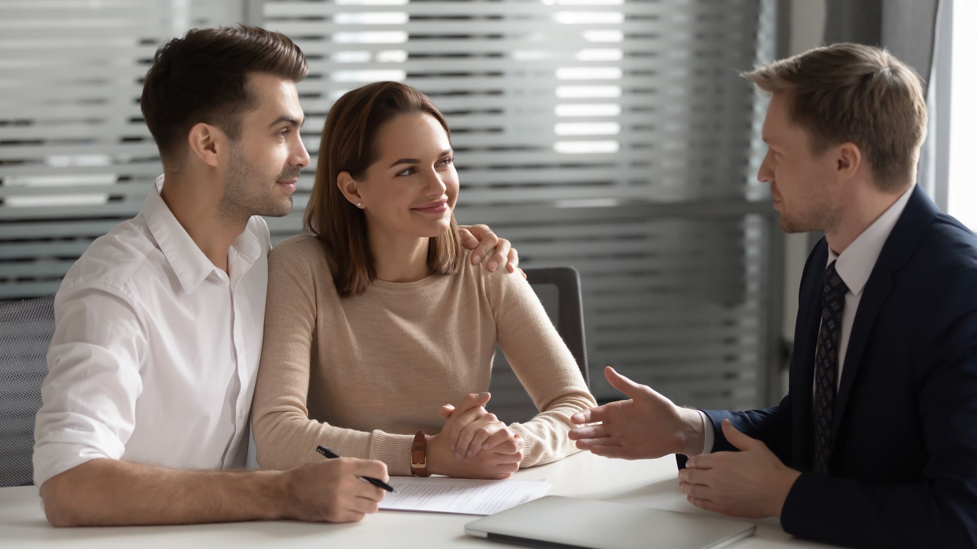 Picture of an insurance agent and two clients at an office discussing coverage options