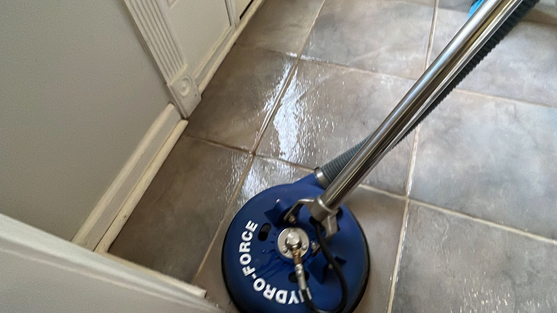 Professional cleaner polish hard floor with high speed machine.Cleaning leady with trolley is in the background.