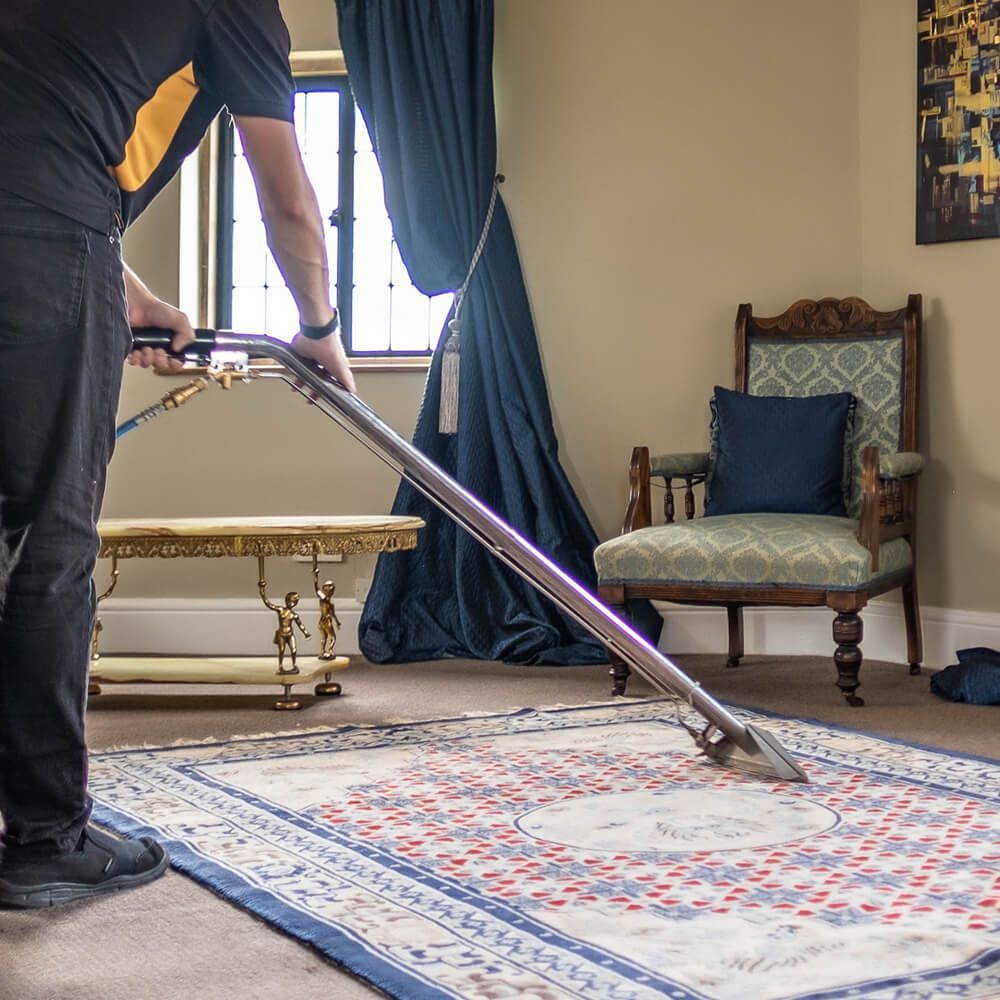 Carpet cleaning with a vacuum cleaner in the house. Cleaner legs close up. Homework concept. Copy space for text.