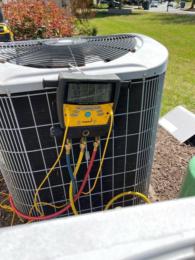 an air conditioner is being serviced with a digital thermometer attached to it .