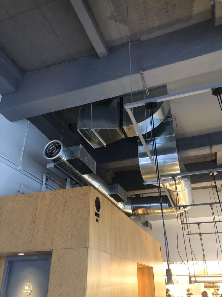 a ceiling with a lot of pipes hanging from it .