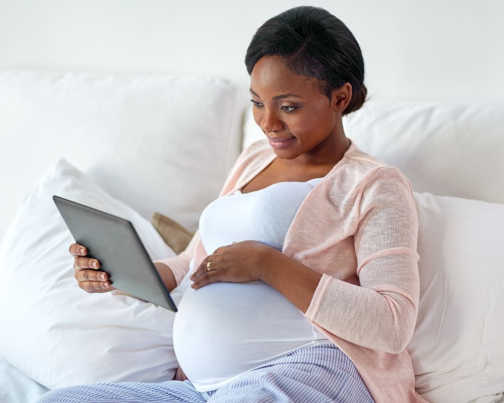 Pregnant Woman is Sitting on a Couch
