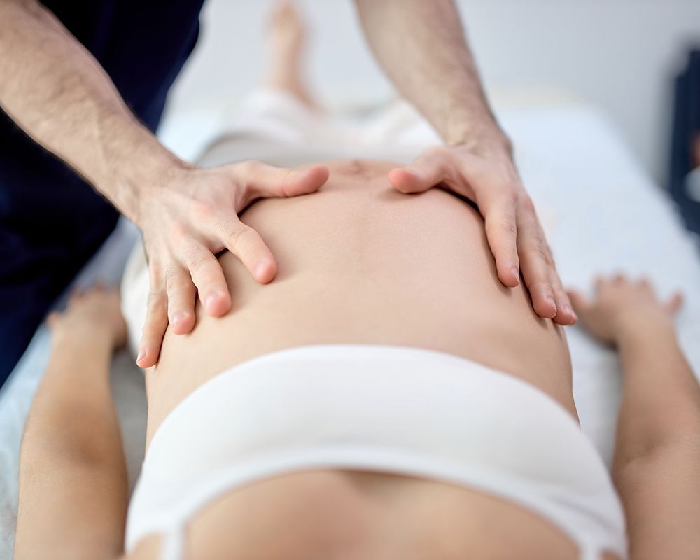 Pregnant Woman is Getting a Massage from a Doctor