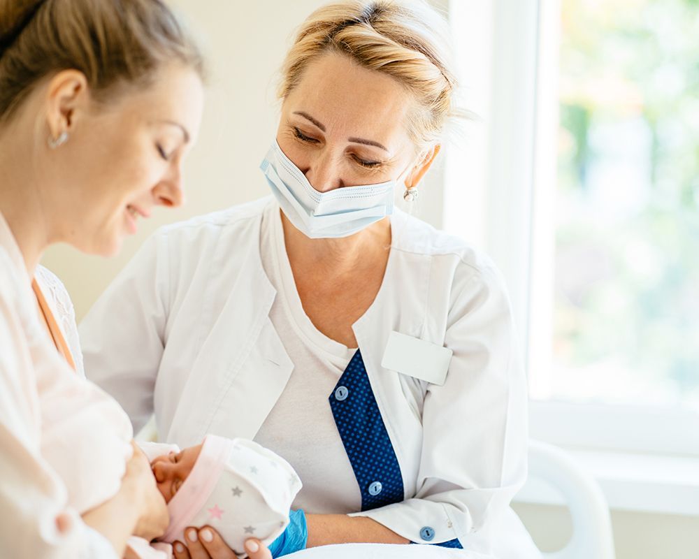 Nurse Feeding a Baby to a Pregnant Woman