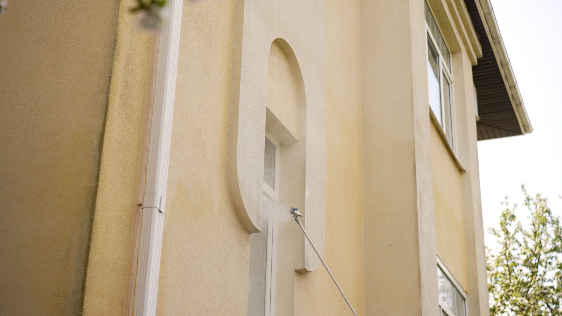 Soft washing stucco exterior with a low-pressure spray