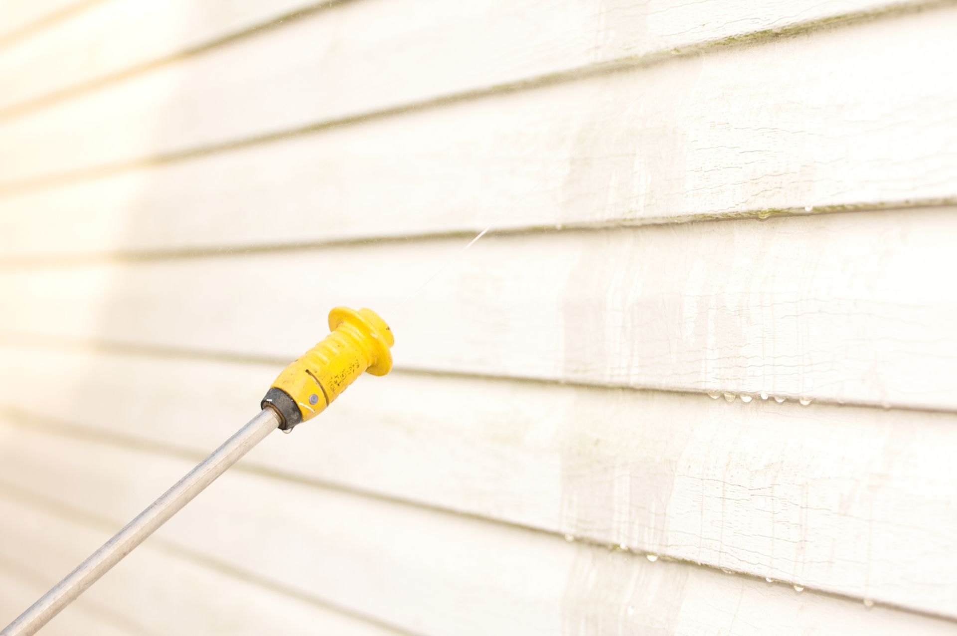 Pressure washing house siding.
