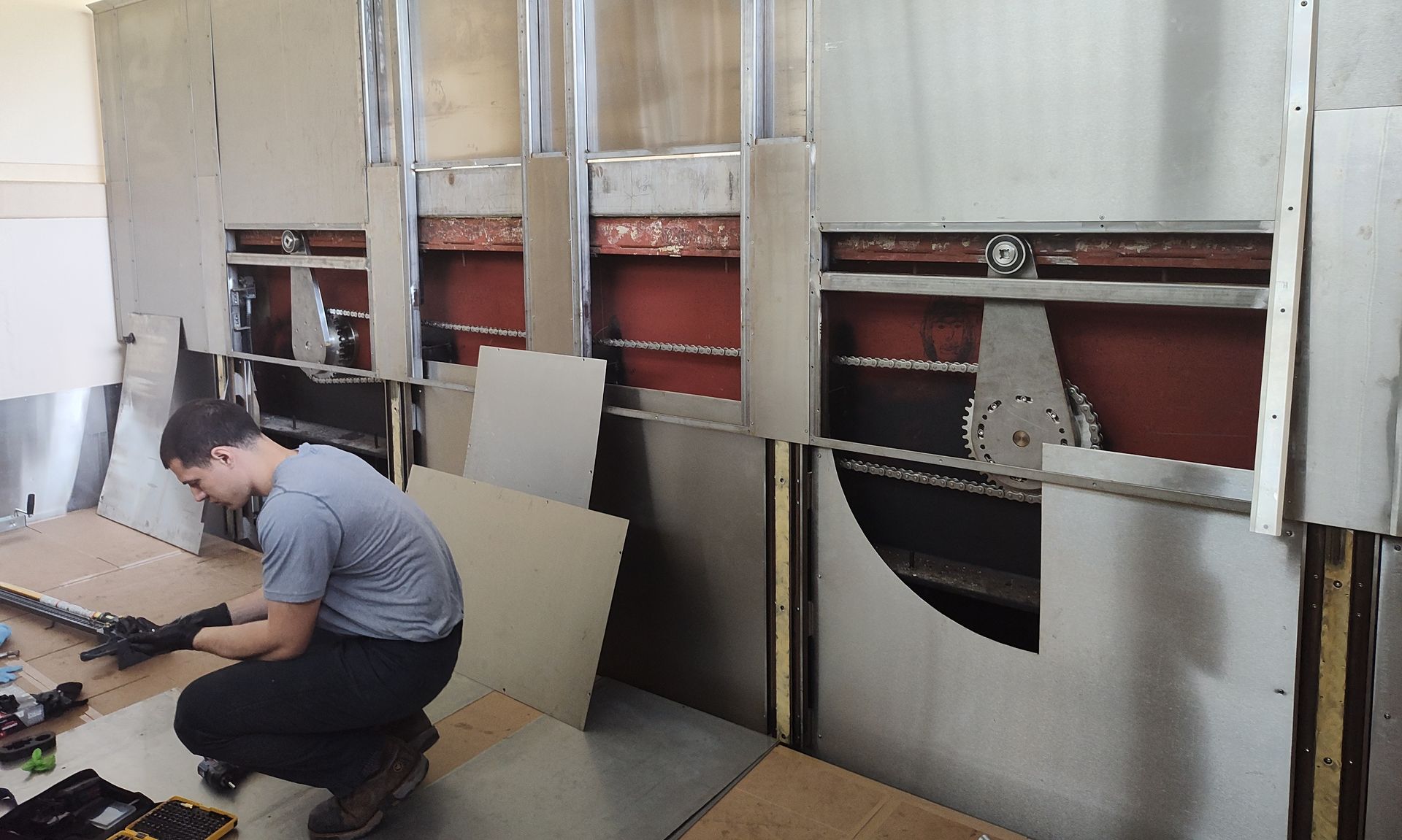 A large stainless steel wall is being built in a room.