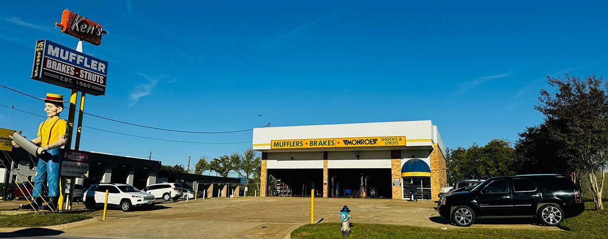 A large statue of a man is standing in front of a car wash.