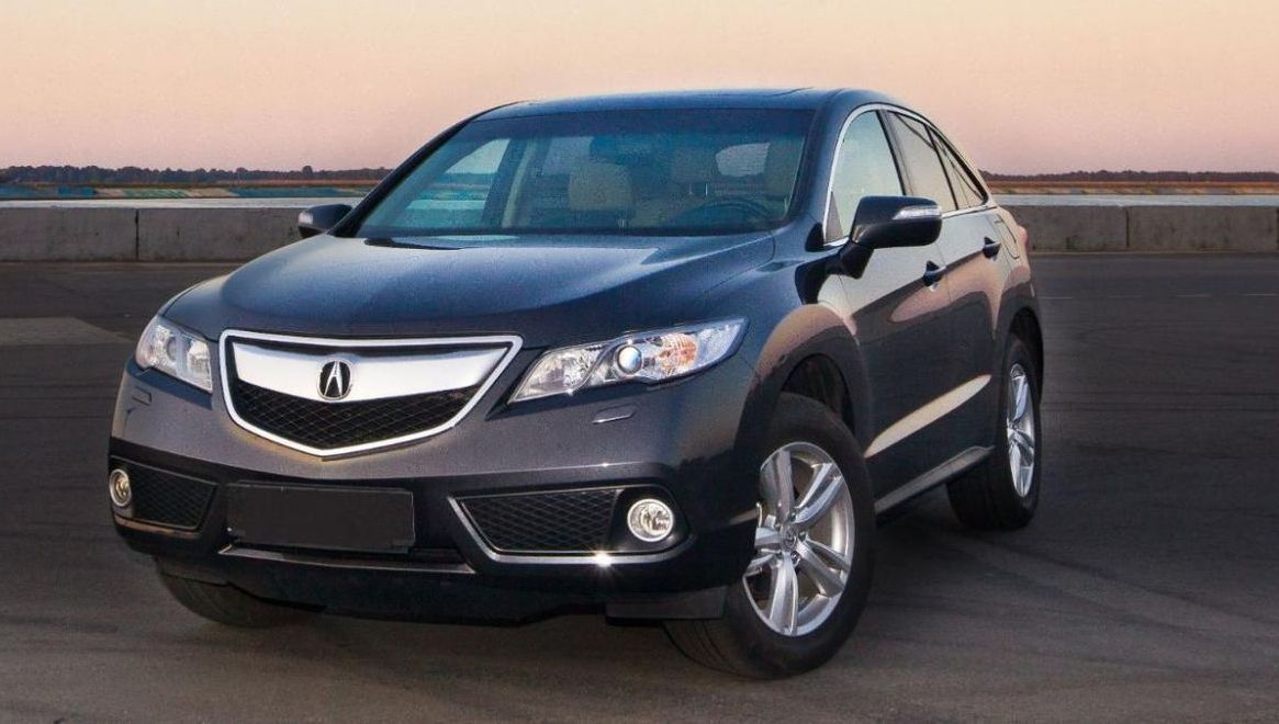 A black acura is parked on the side of the road