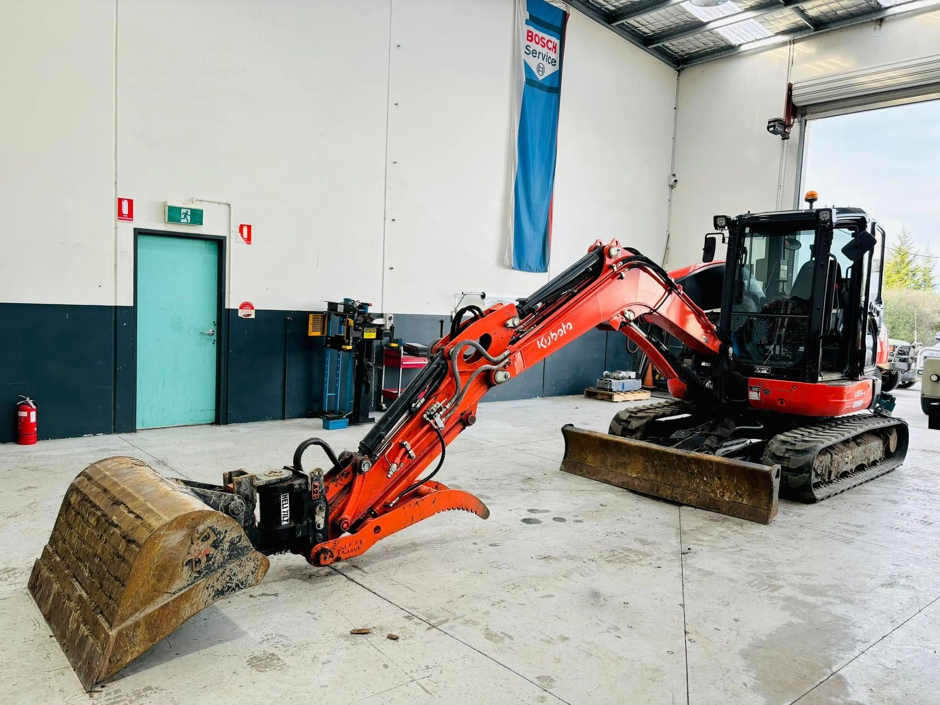 A Bright Orange Kubota Mini Excavator With a Bucket Attachment — Roberts Automotive & Industrial in Brighton, TAS