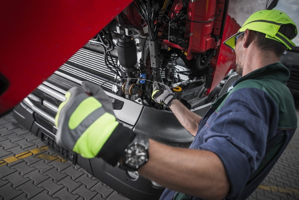 A Mechanic in Cap and Gloves Performs Maintenance on Truck — Roberts Automotive & Industrial in Brighton, TAS
