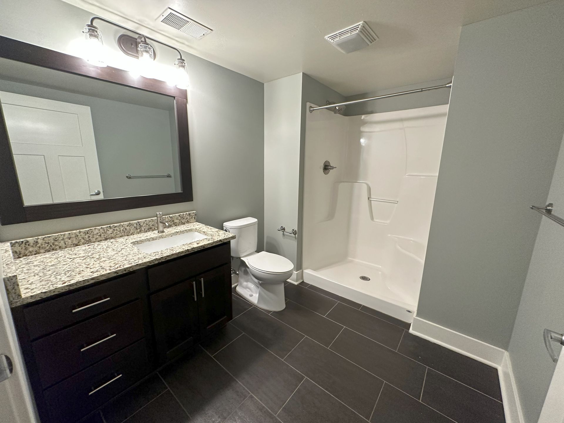 Modern bathroom with vanity and tile flooring at River Flats apartments