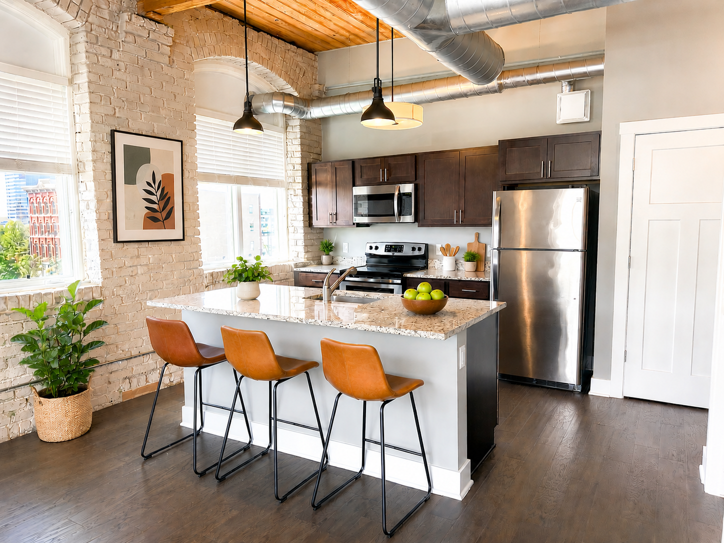 Updated kitchen with stainless steel appliances and quartz countertops at River Flats apartments