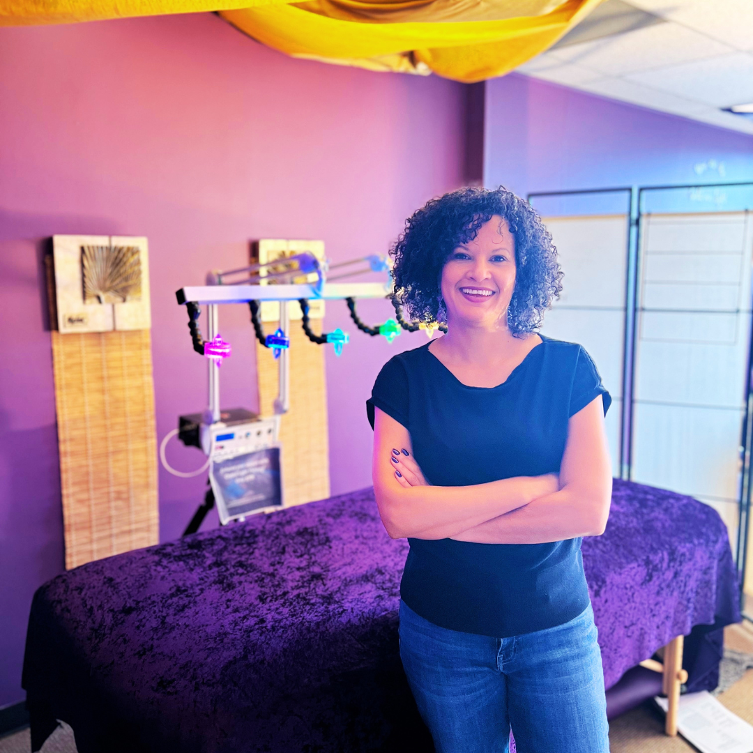 Energy healer Dena Gould standing next to her crystal light  bed for healing therapy sessions in Denver