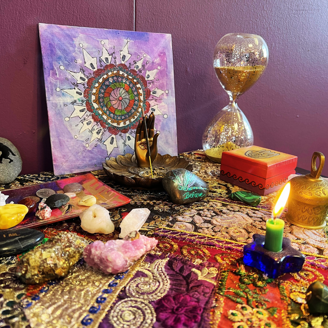 A sacred space with candles, mandala, crystals and spiritual items in Dena Gould's Denver office