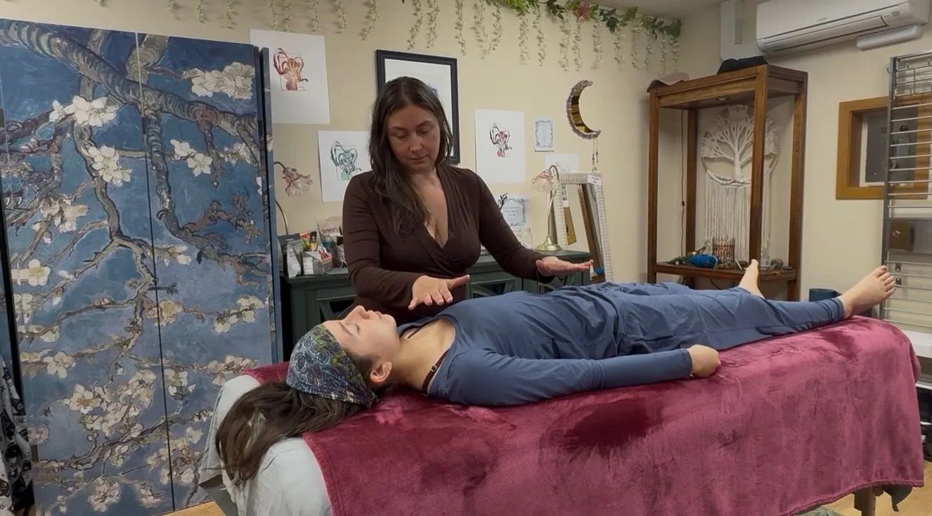 Therapist working on a client lying on a massage table in a calm treatment room